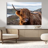 71222-MGV-CV-36X24-A playful Highland cow with shaggy fur sticks out its tongue, set against a rugged landscape — perfect for quirky home or office