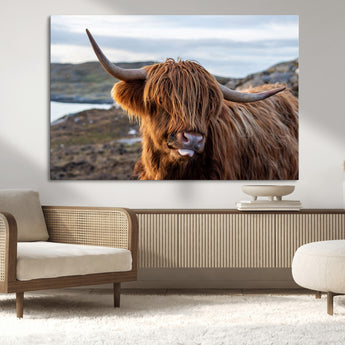 71222-MGV-CV-36X24-A playful Highland cow with shaggy fur sticks out its tongue, set against a rugged landscape — perfect for quirky home or office