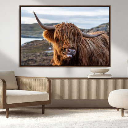 71222-MGV-FC-36X24_Walnut-A playful Highland cow with shaggy fur sticks out its tongue, set against a rugged landscape — perfect for quirky home or office
