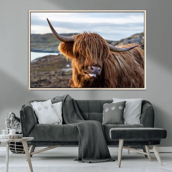 71222-MGV-CV-36X24-A playful Highland cow with shaggy fur sticks out its tongue, set against a rugged landscape — perfect for quirky home or office