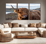 71222-MGV-CV-36X24-A playful Highland cow with shaggy fur sticks out its tongue, set against a rugged landscape — perfect for quirky home or office